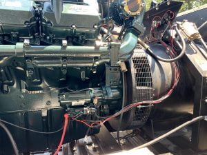 Close-up of a diesel engine coupled to an alternator on a generator skid