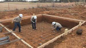 Crew tying rebar inside the formwork for a concrete equipment foundation